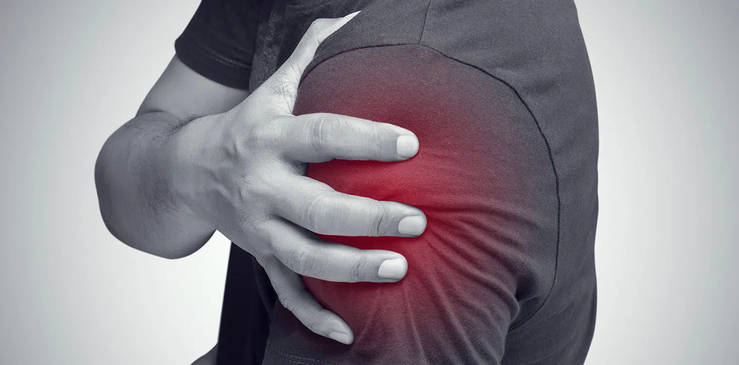 Image de main d un homme tenant son epaule qui lui fait mal - epaule douloureuse capsulite retractile | IK Paris