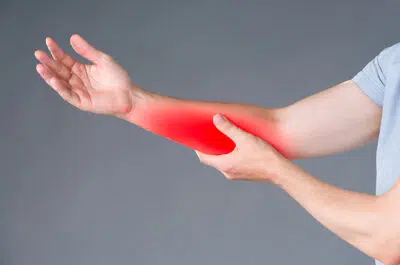 Image d un homme tenant son avant bras avec sa main - fracture de l avant bras | IK Paris