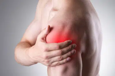 Image de jeune homme tenant son epaule avec sa main - luxation d epaule | IK Paris