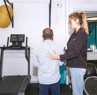Homme debout devant un tapis de course pendant une séance de rééducation - douleur chronique institut de kinésithérapie Paris (IK)