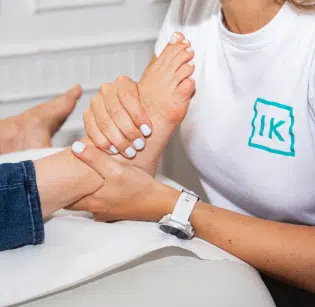 Kinésithérapeute faisant un Massage plantaire- cheville et pied institut de kinésithérapie Paris (IK)
